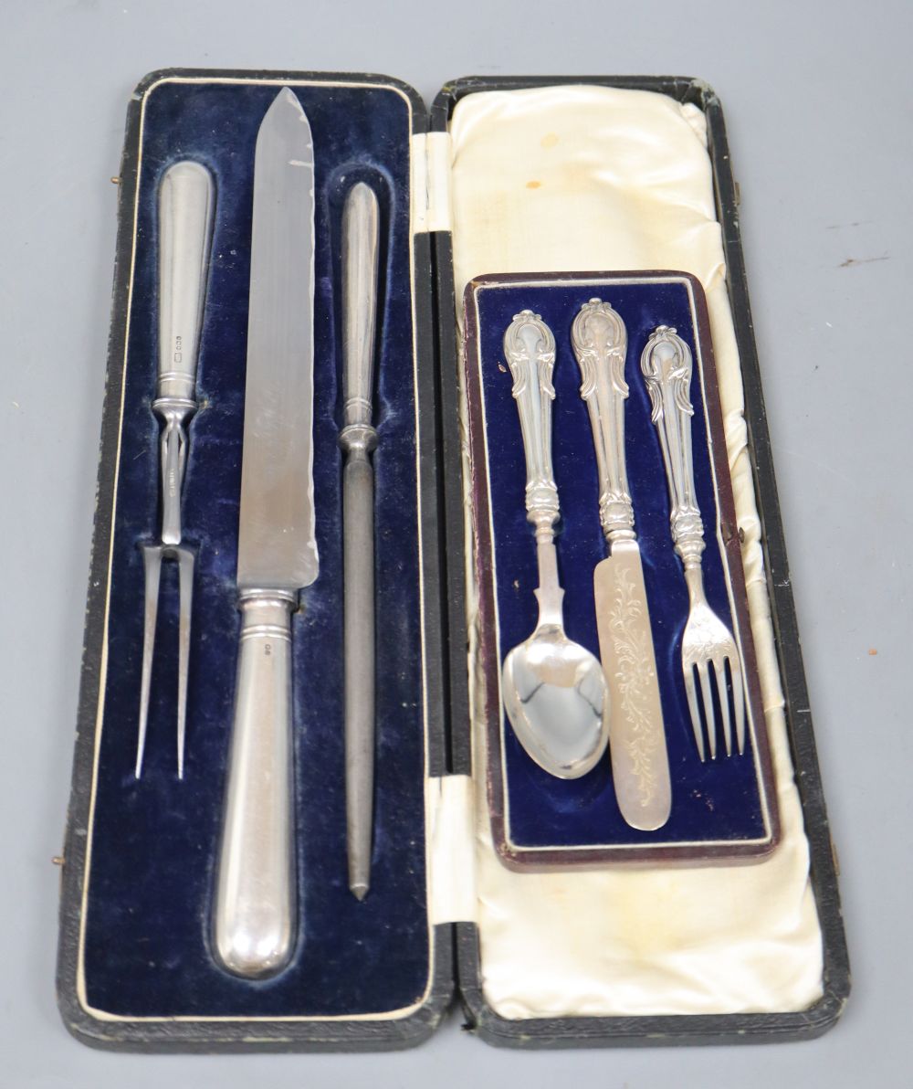 A cased Edwardian silver handled three piece carving set and a cased plated christening trio.
